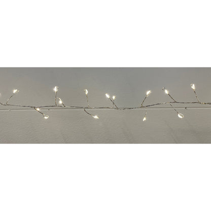 String of small lights on a branch against a plain background