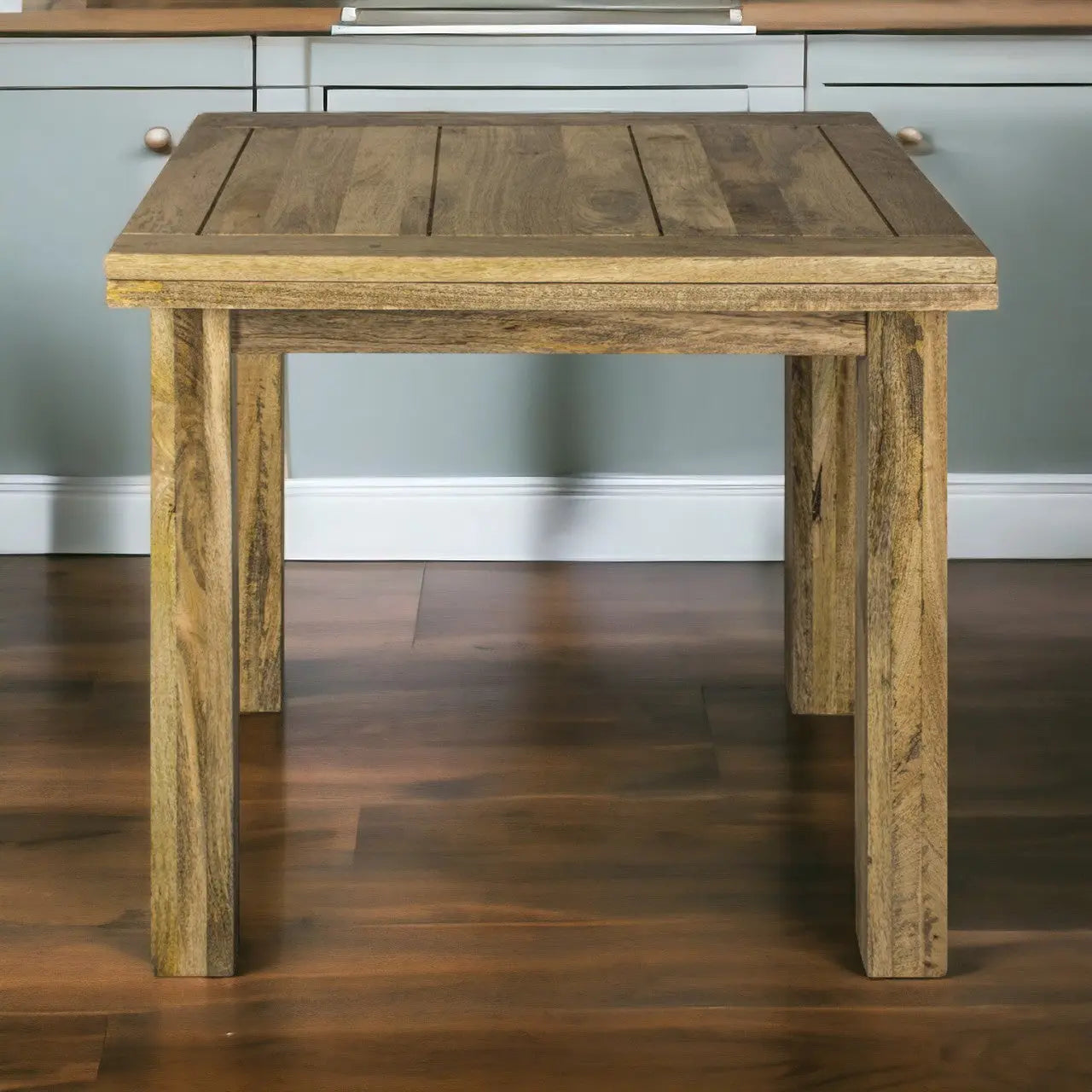 Wooden side table in a room with gray walls and wooden floor.