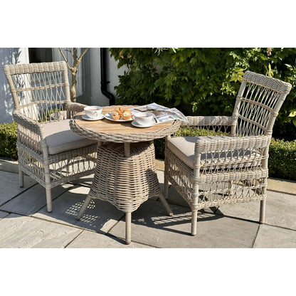 Wicker outdoor furniture set with a small table and two chairs on a patio.