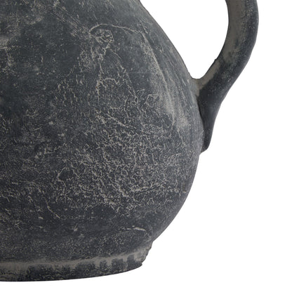 Close-up of a textured black ceramic vase on a white background