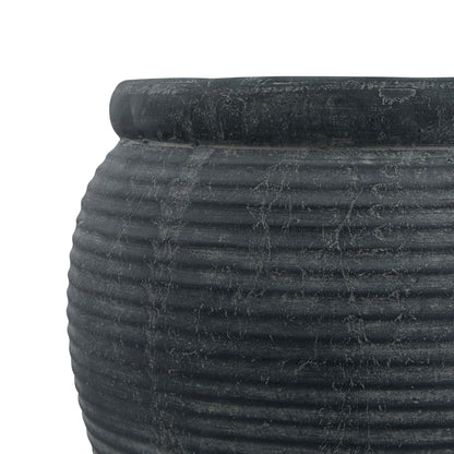 Close-up of a textured black pot on a white background