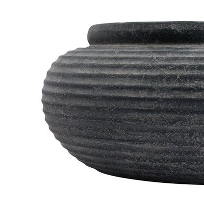 Close-up of a textured black stone bowl on a white background