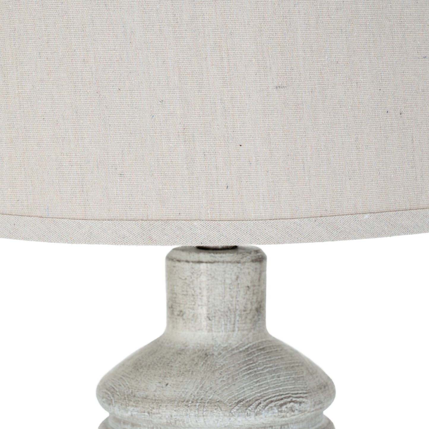 Close-up of a textured lamp base with a light gray fabric lampshade on a white background