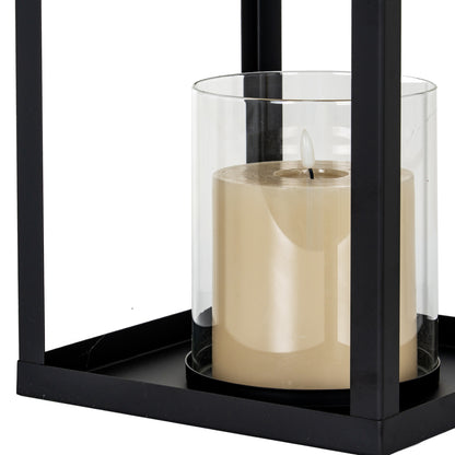 Candle in a black holder with a clear glass cover on a white background