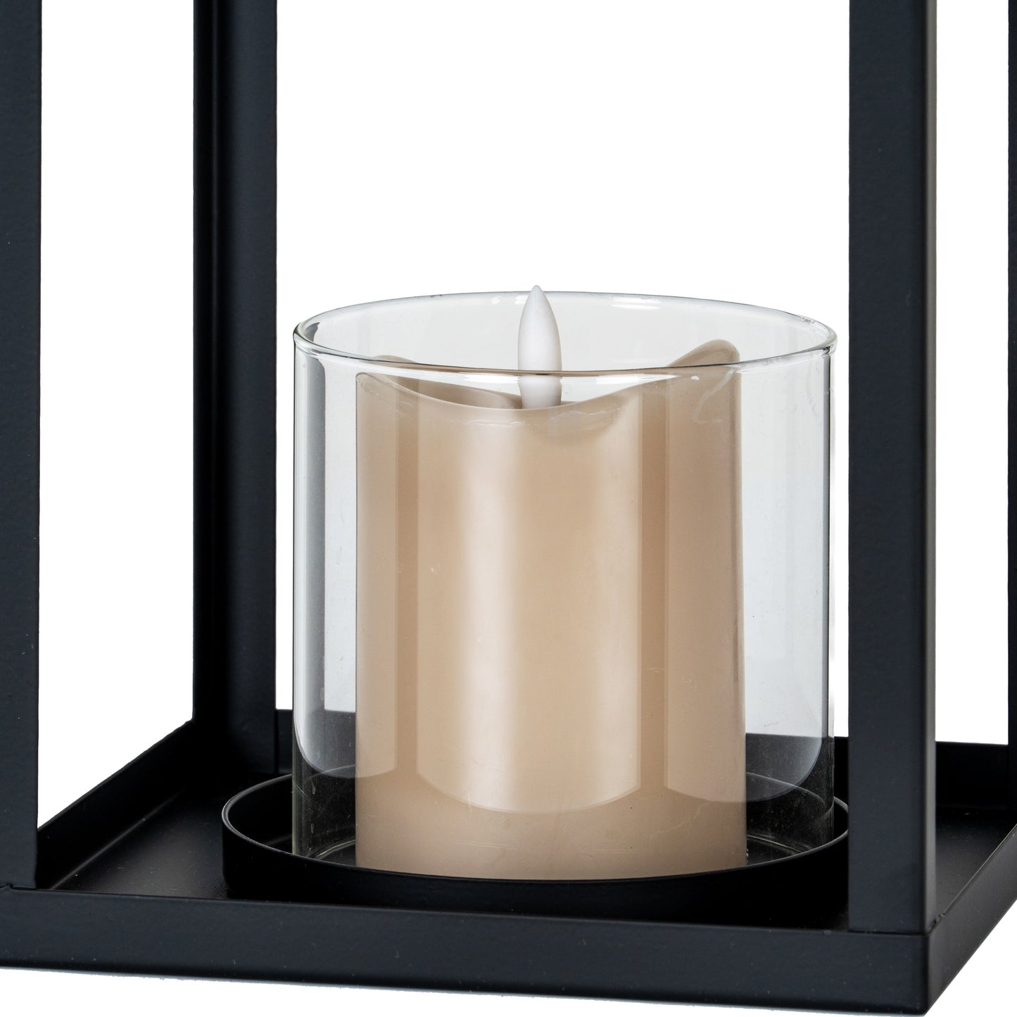 Candle in a glass holder inside a black lantern on a white background