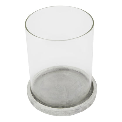 Clear glass candle holder with a concrete base on a white background