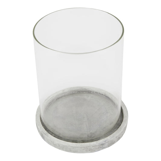 Clear glass candle holder with a concrete base on a white background
