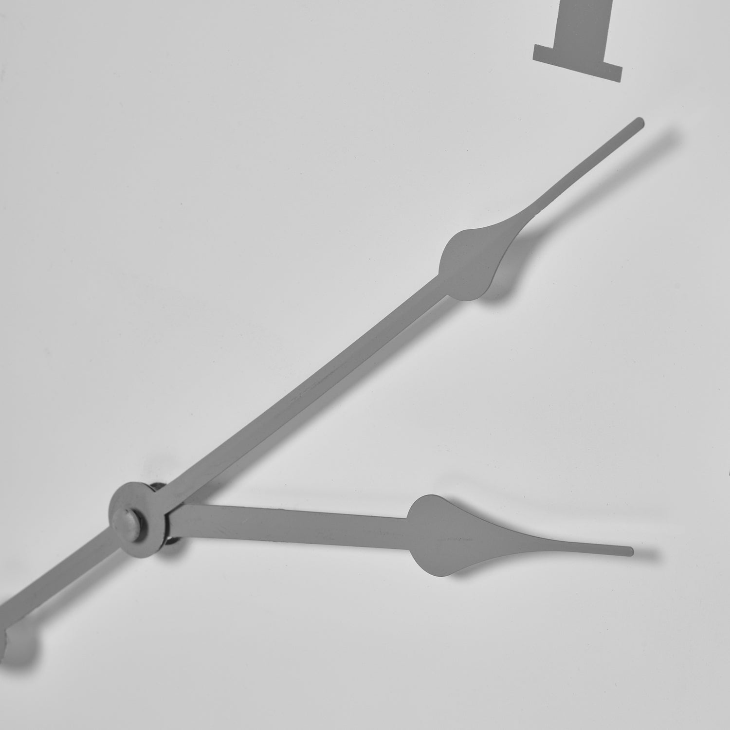 Close-up of a clock with gray hands on a light gray background