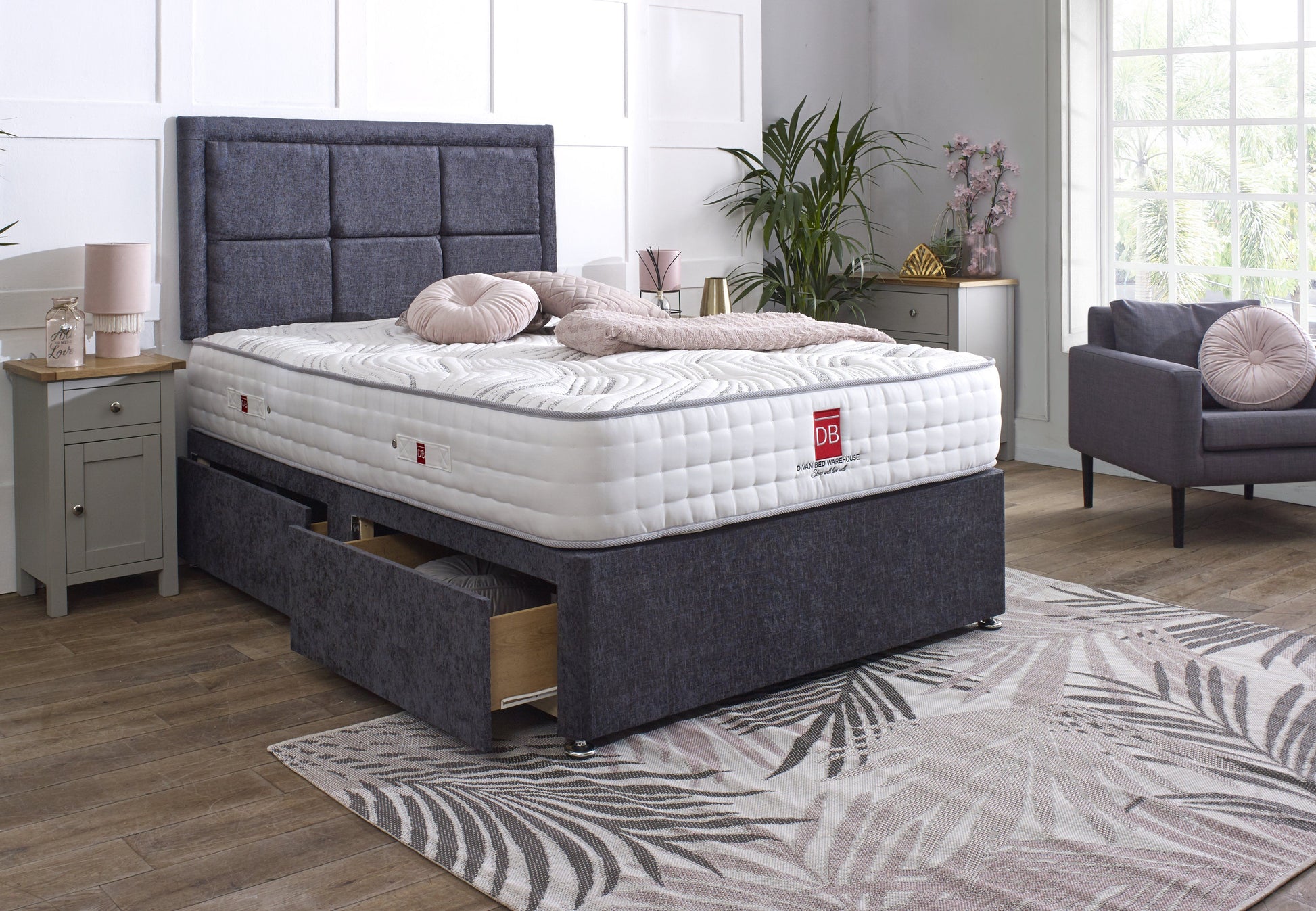 Bed with gray upholstered headboard and matching footboard in a room setting.