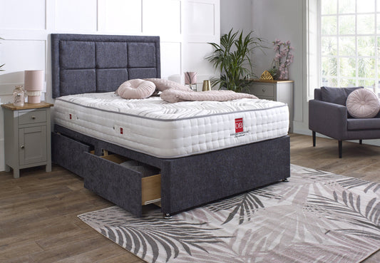 Bed with gray upholstered headboard and matching footboard in a room setting.