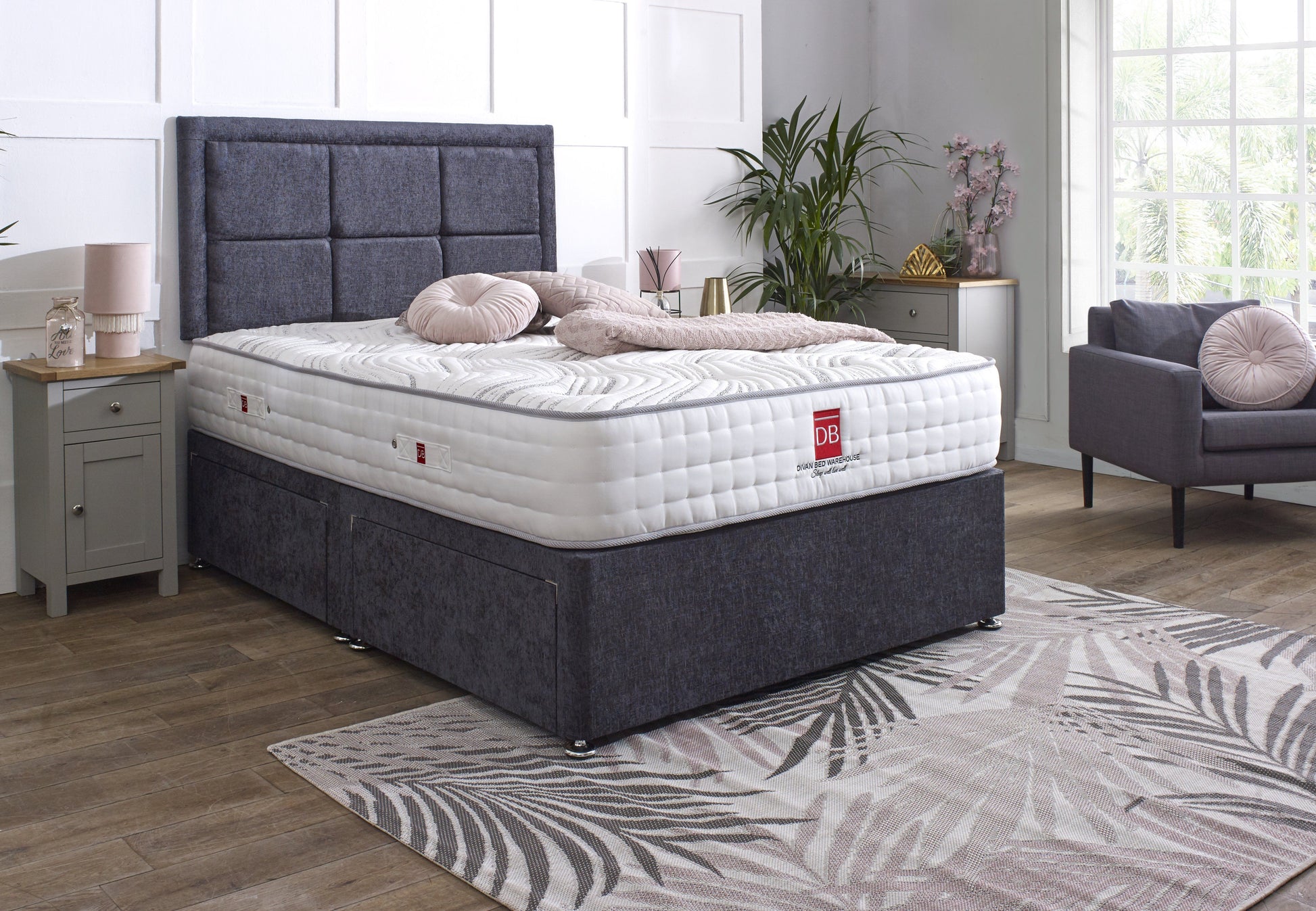 Bed with gray upholstered headboard and white mattress in a bedroom setting.