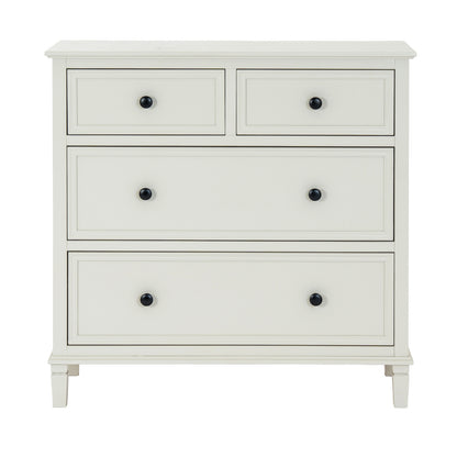 White dresser with four drawers and black knobs on a white background