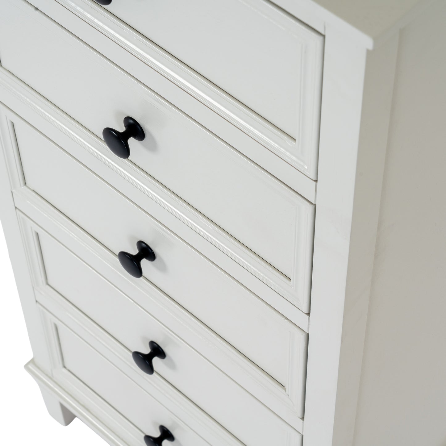 White dresser with black knobs on a plain background