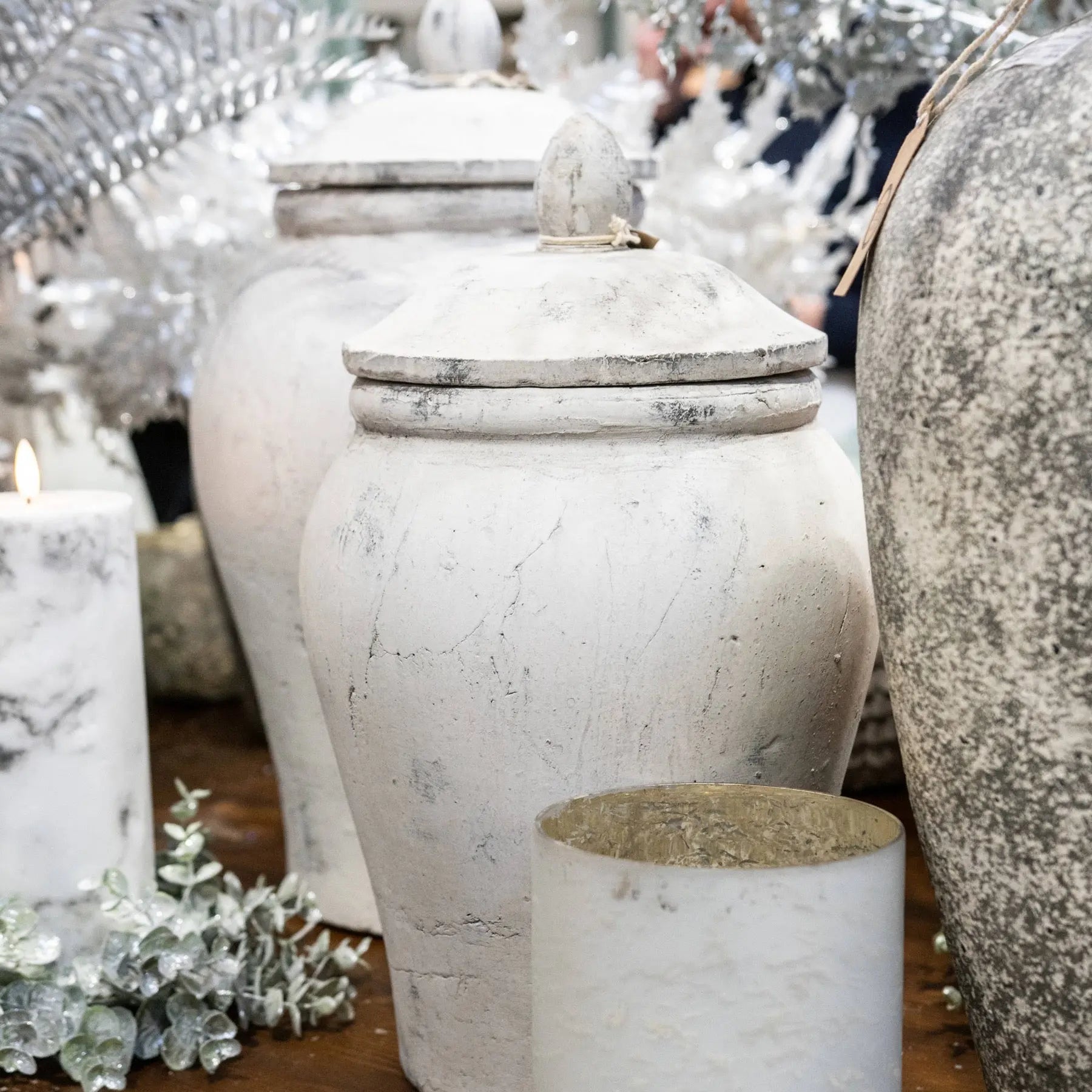 Decorative urns with a rustic finish on a wooden surface.
