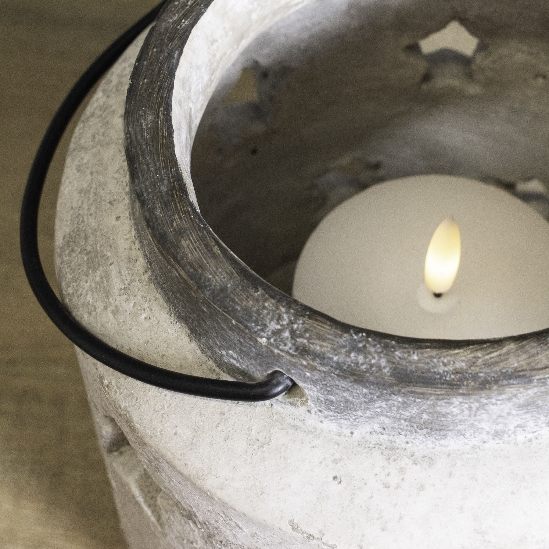 Candle in a concrete holder with a black wire