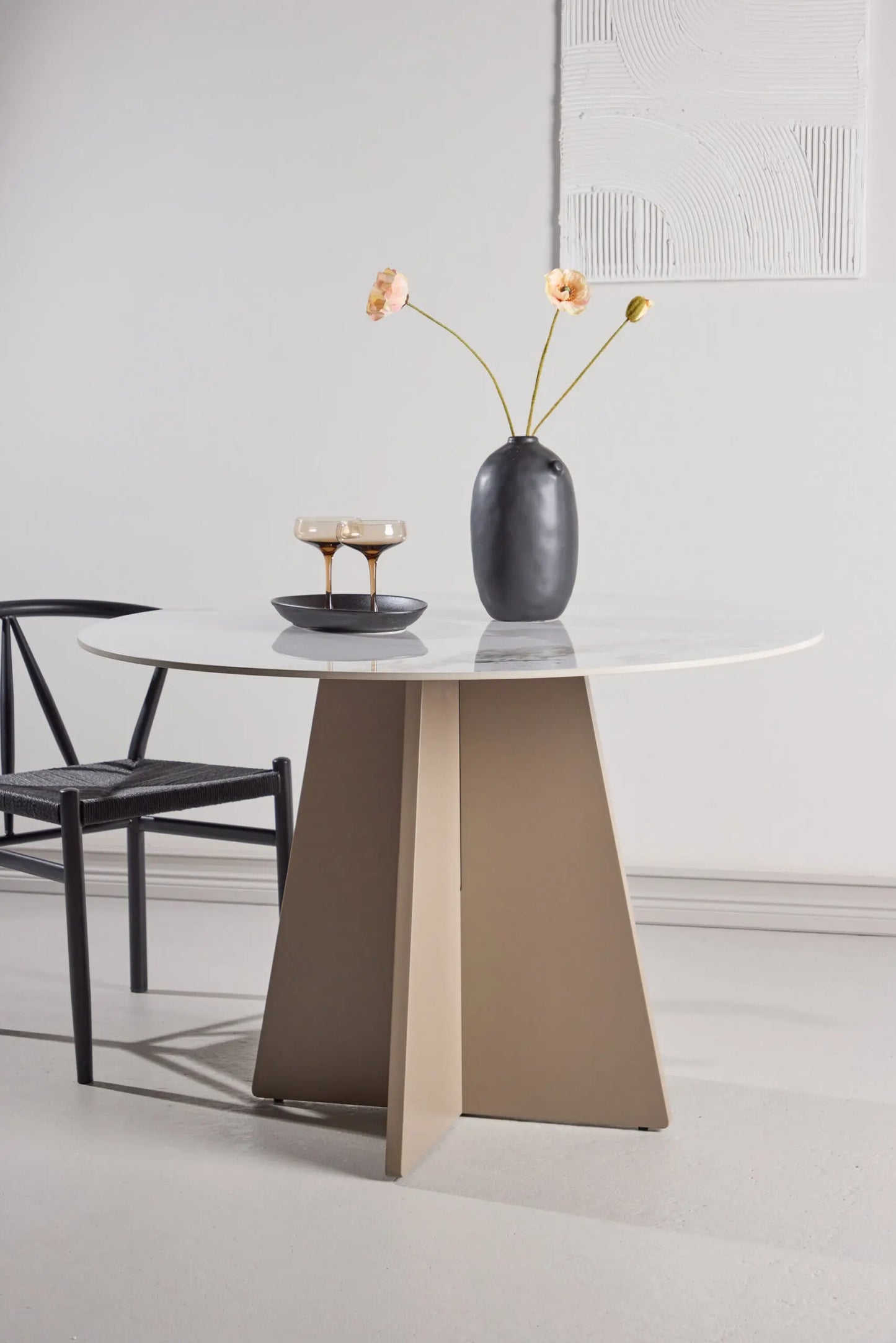 Modern dining table with a vase and glasses on a white background