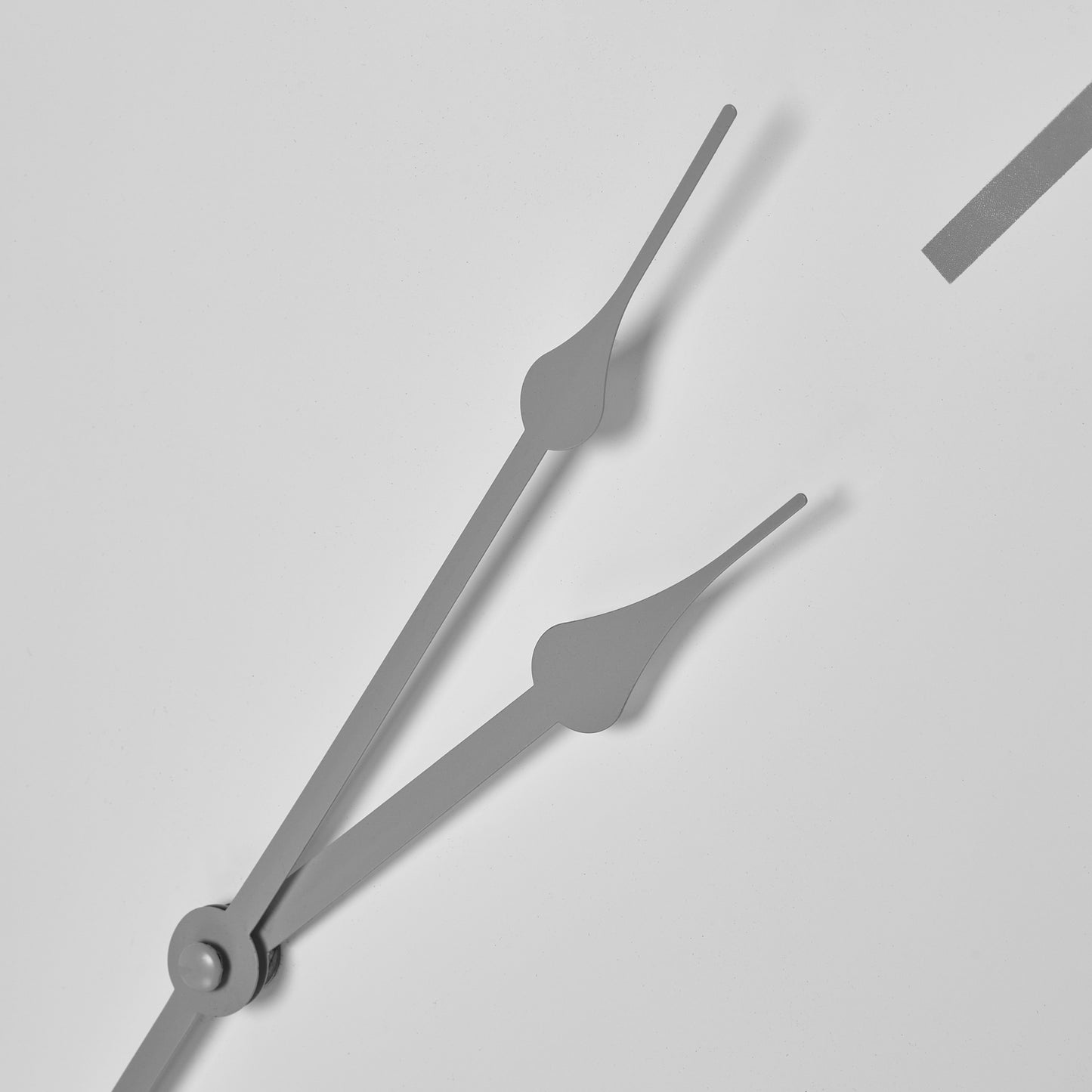Close-up of clock hands on a light gray background