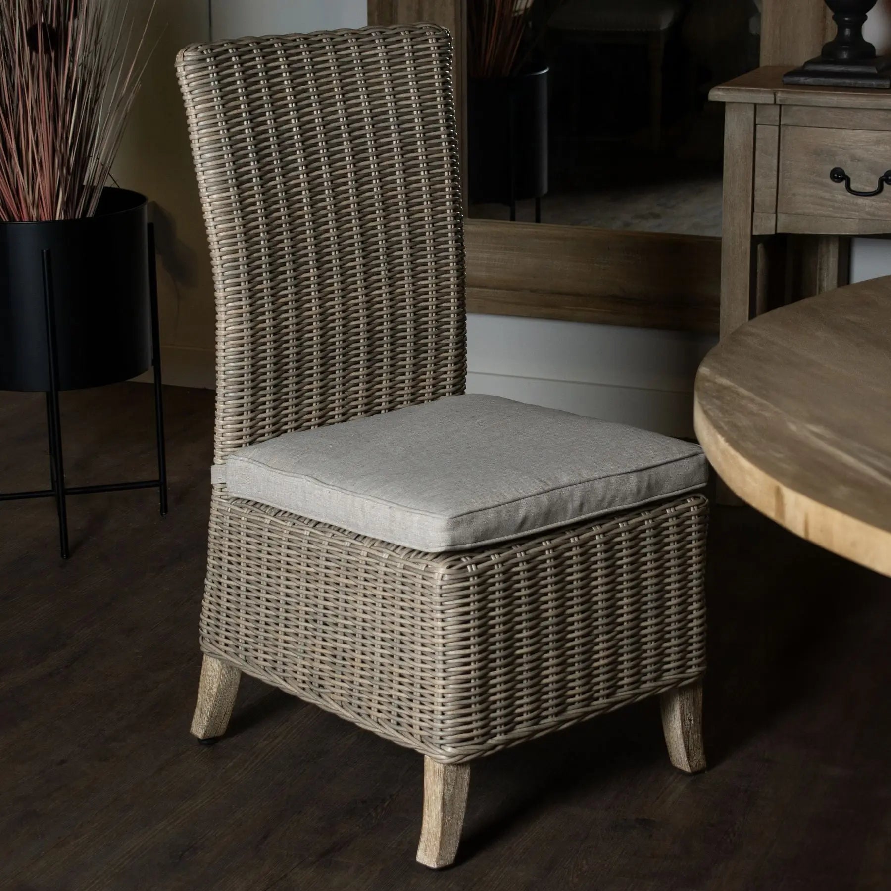 Wicker chair with a cushion in a room setting