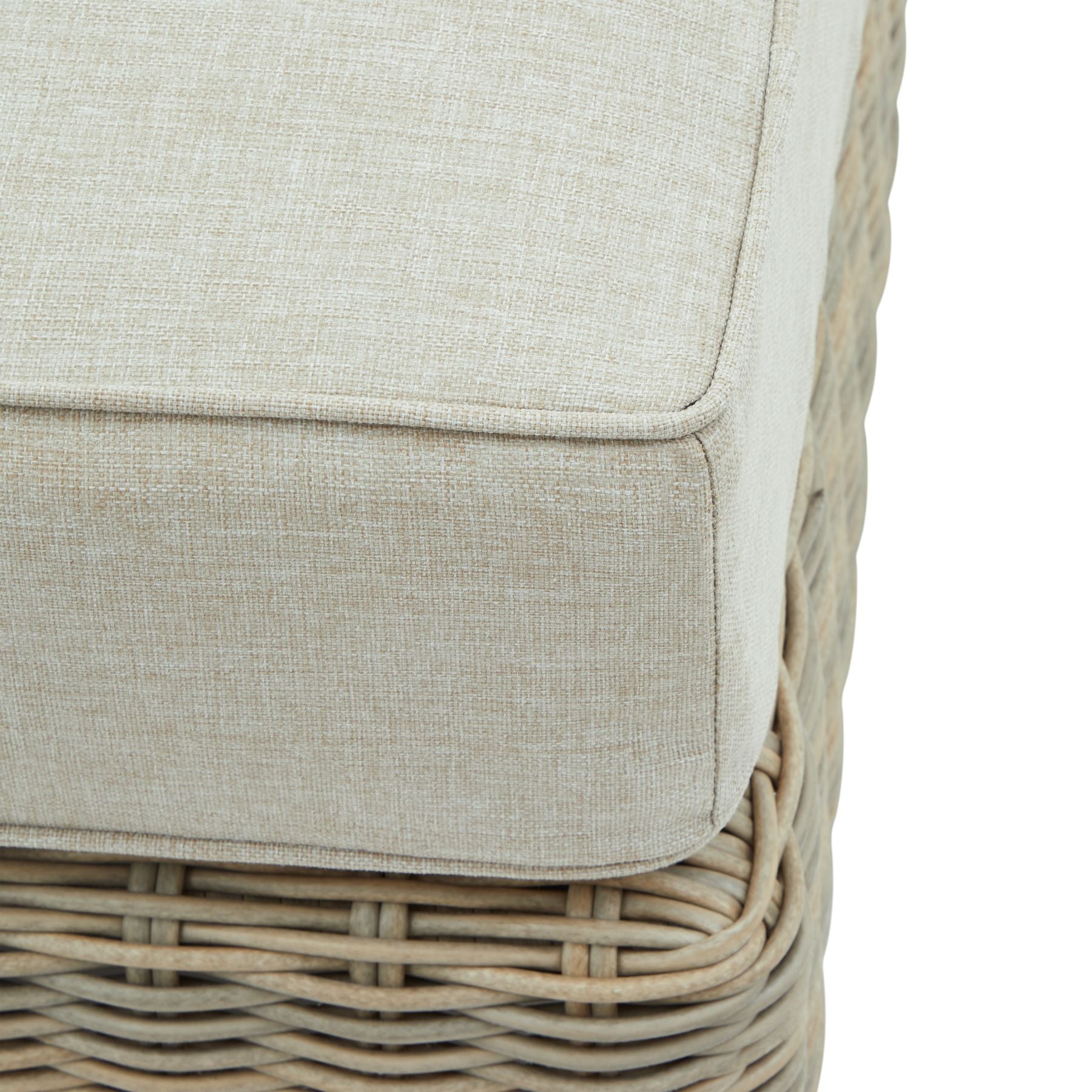 Close-up of a wicker chair with a beige cushion on a white background