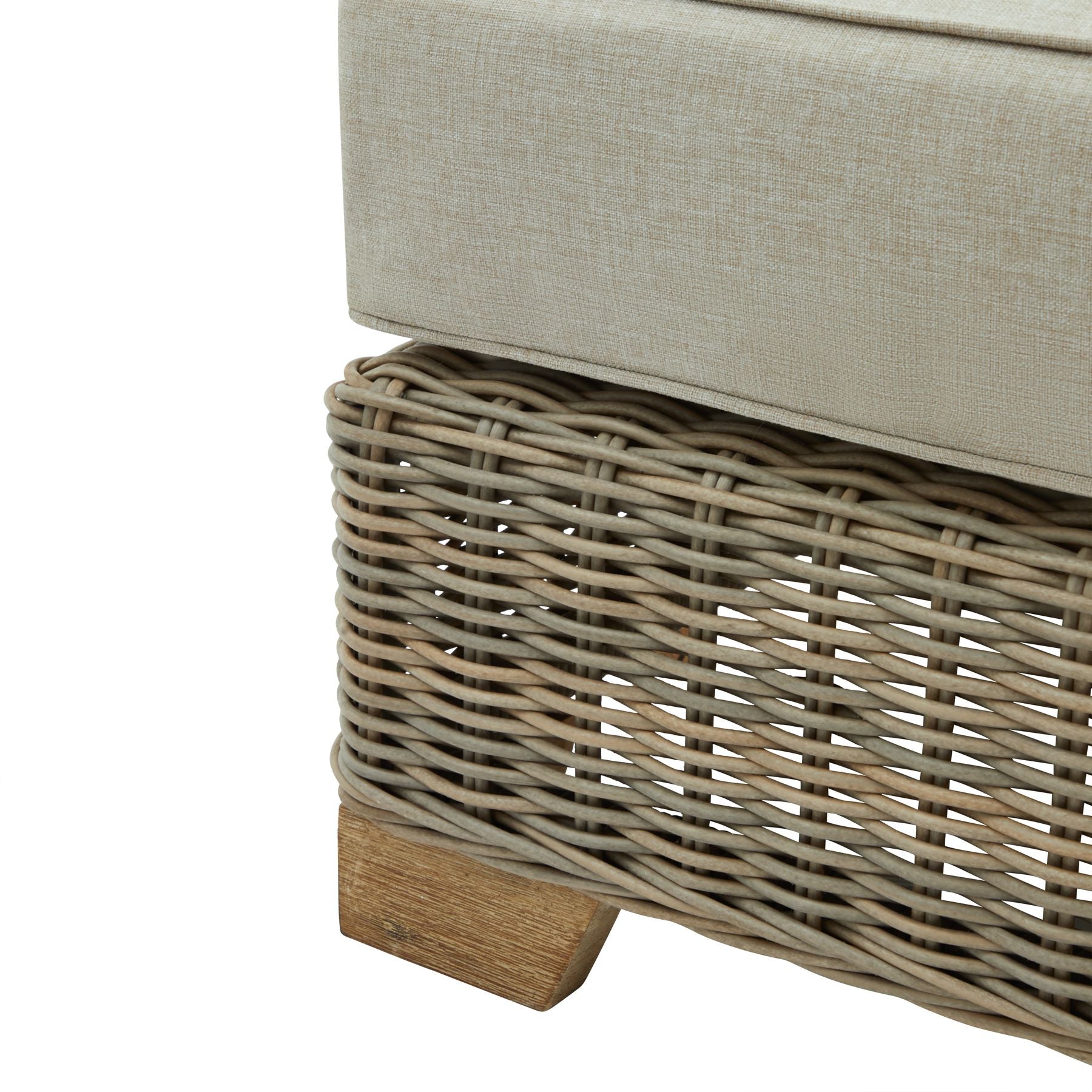 Cushioned ottoman with wicker base on a white background