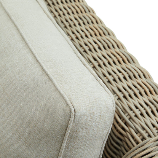 Close-up of a beige cushion on a wicker chair