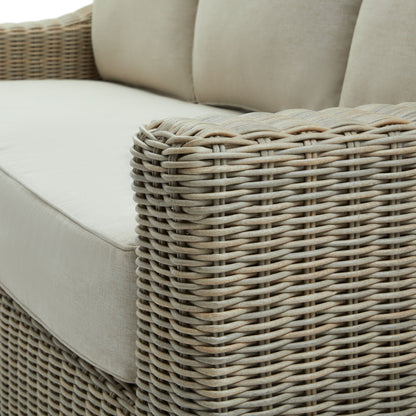 Close-up of a wicker outdoor sofa with beige cushions