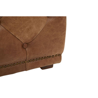 Close-up of a brown leather armchair with buttoned details on a white background