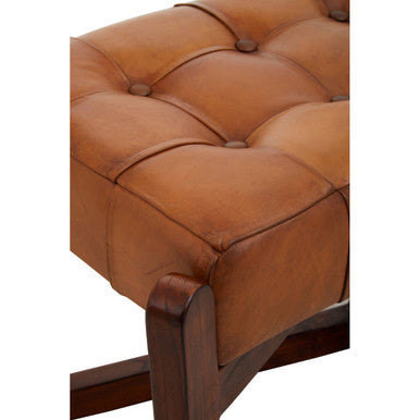 Close-up of a brown leather sofa with tufted backrest on a white background