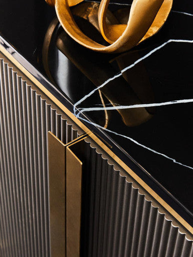 Close-up of a decorative piece with black marble surface and gold accents