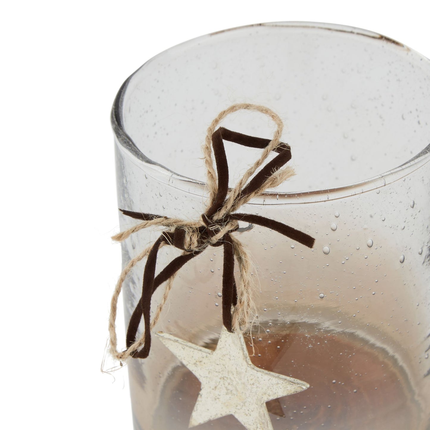 Clear glass candle holder with a star-shaped ornament and brown ribbon on a white background