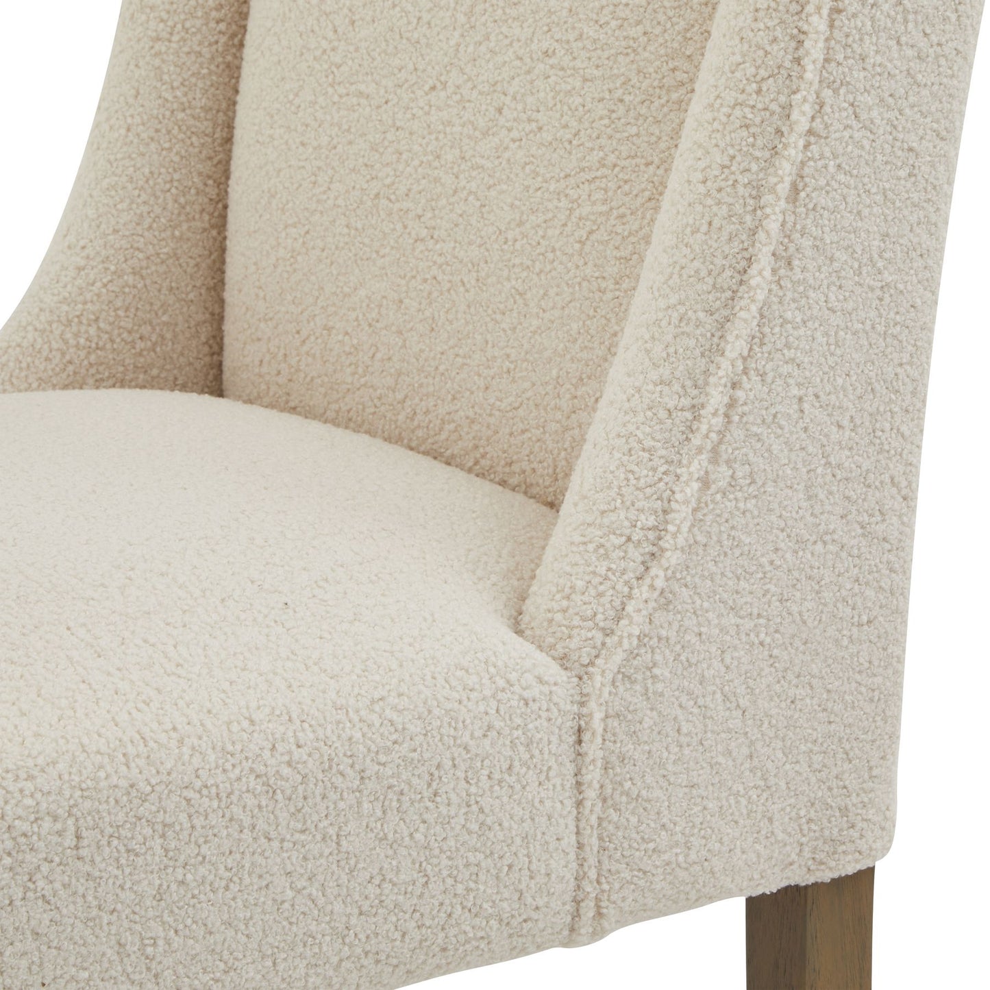 Close-up of a beige upholstered chair with a textured fabric finish.