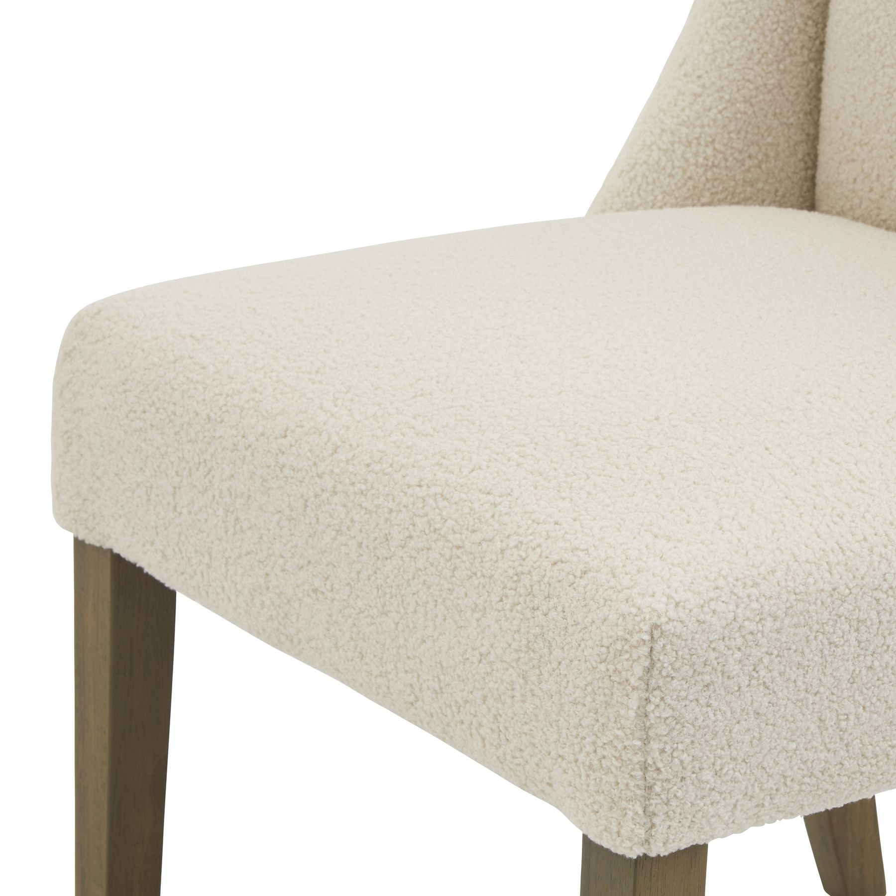 Close-up of a beige upholstered chair with wooden legs on a white background