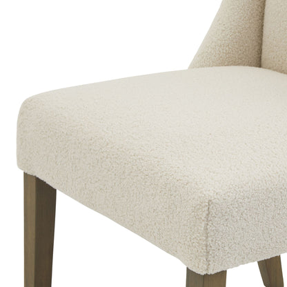 Close-up of a beige upholstered chair with wooden legs on a white background