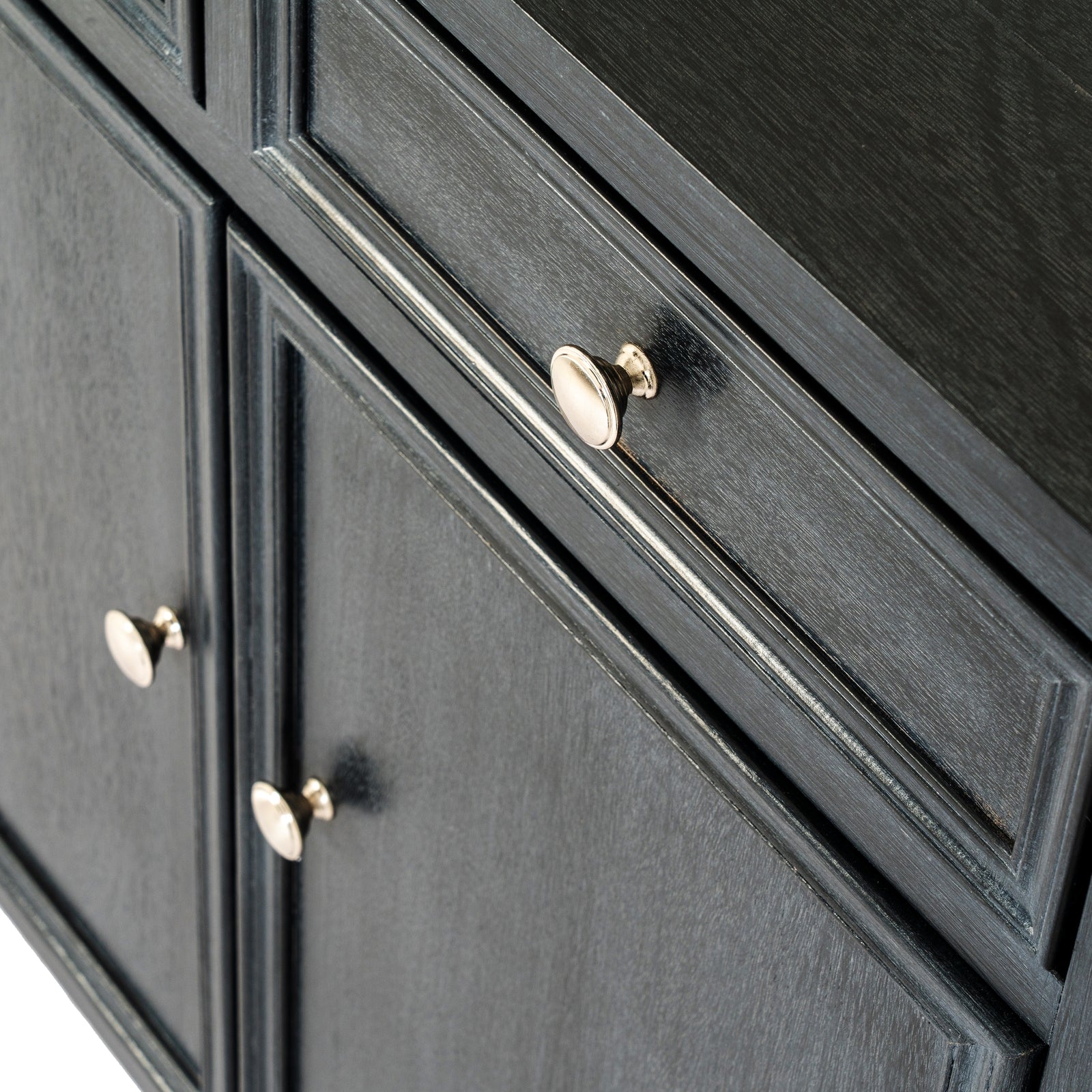 Close-up of a black cabinet with gold knobs