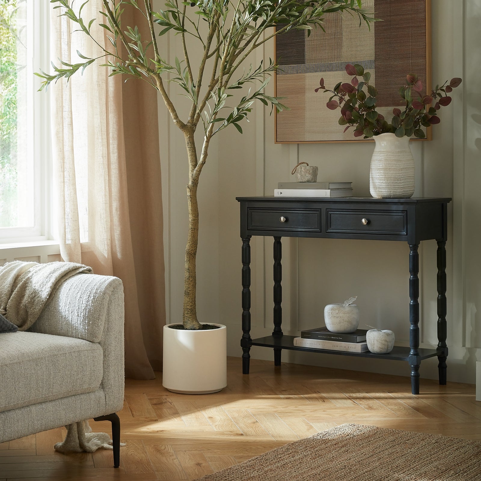 Living room with a console table, armchair, and decorative plant.