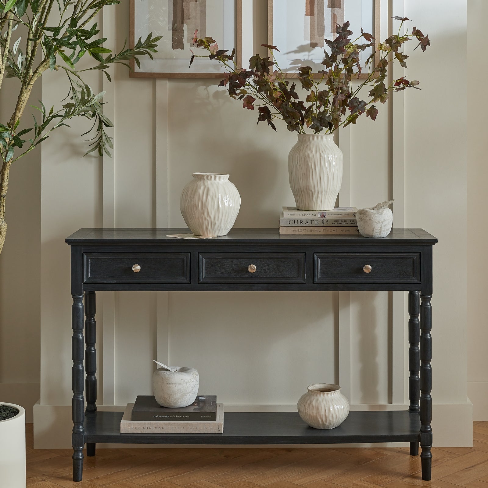 Black console table with decorative items against a neutral wall