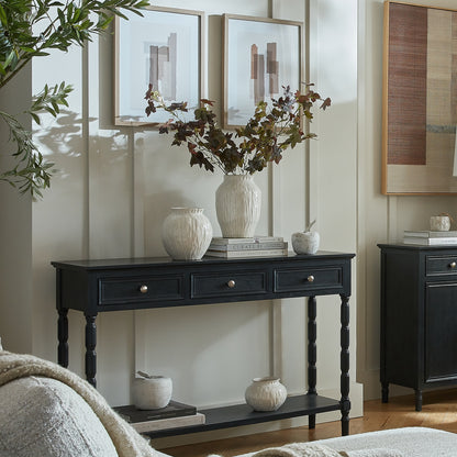 Black console table with decorative items in a room setting