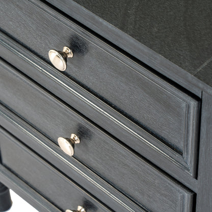 Close-up of a dark gray dresser with gold knobs on a white background