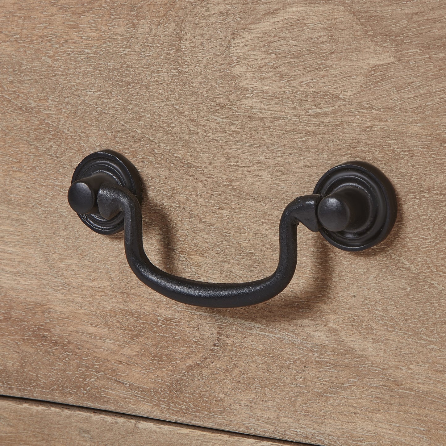 Black metal handle on a wooden surface