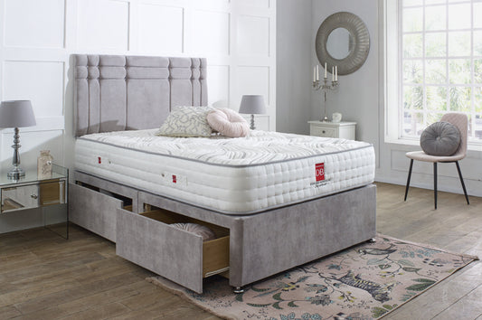 Gray upholstered bed with white mattress in a bedroom setting