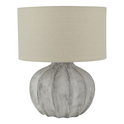Table lamp with textured gray base and beige lampshade on a white background