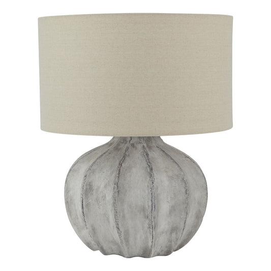 Table lamp with textured gray base and beige lampshade on a white background