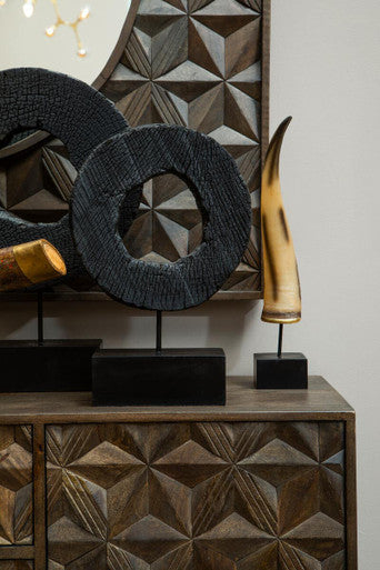 Decorative items on a wooden cabinet with geometric wall art in the background