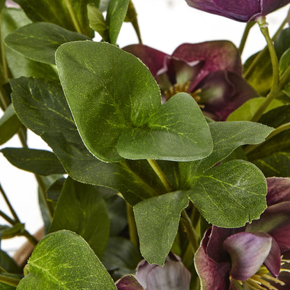 Close-up of green leaves and purple flowers with a blurred background