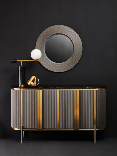 Modern bathroom vanity with round mirror and decorative elements against a black wall.