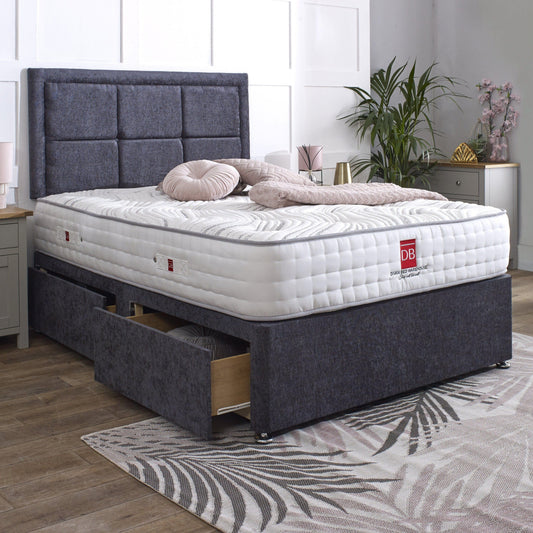 Gray upholstered bed with white mattress and drawers in a bedroom setting.
