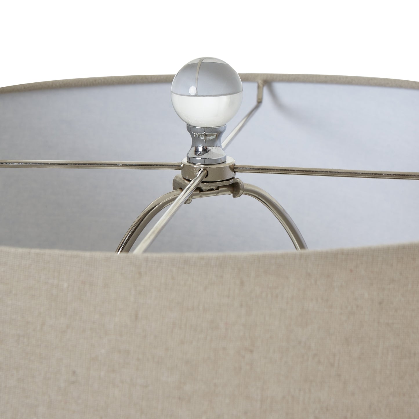 Close-up of a lamp with a beige shade and metallic base.