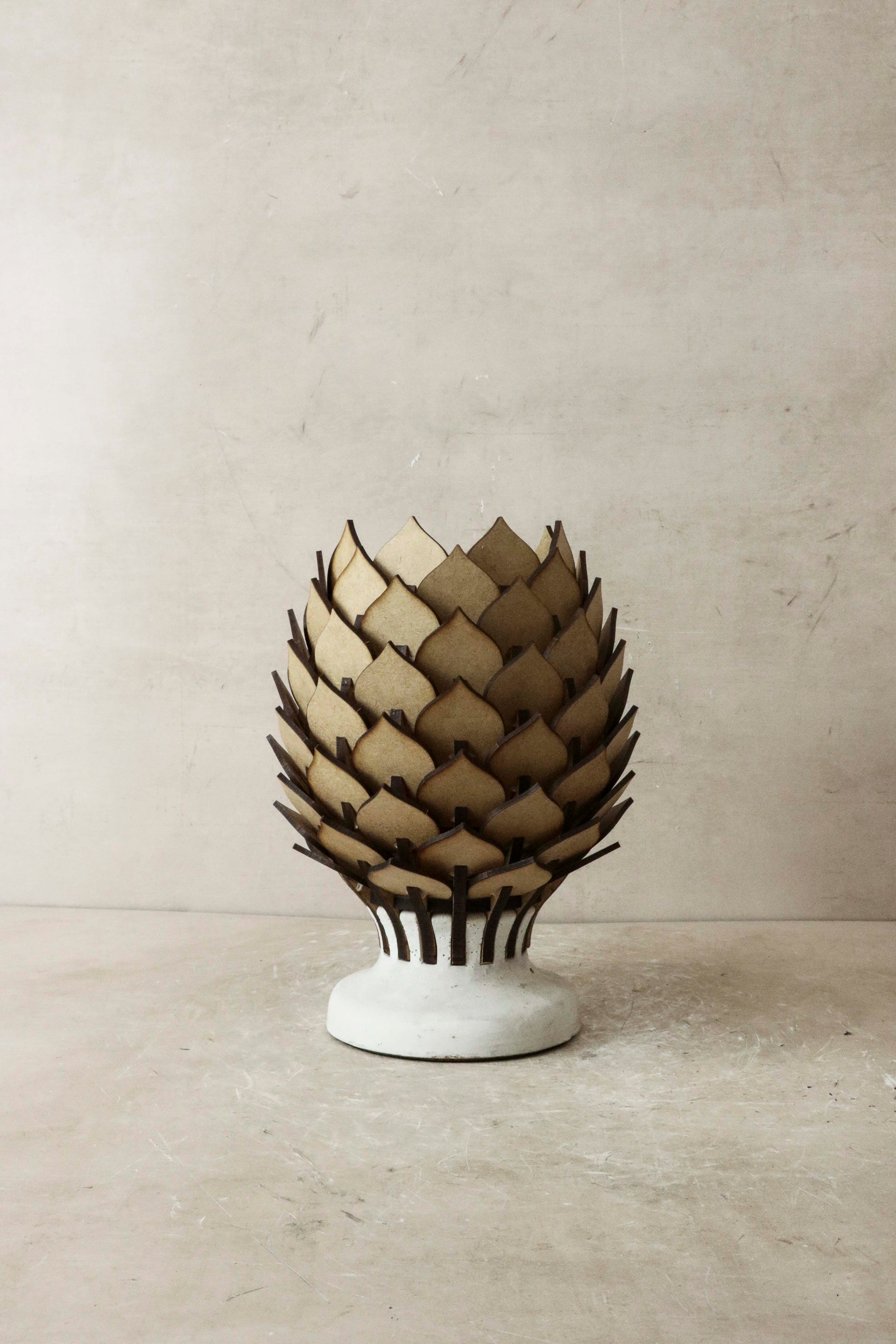 Decorative artichoke-shaped lamp on a neutral background