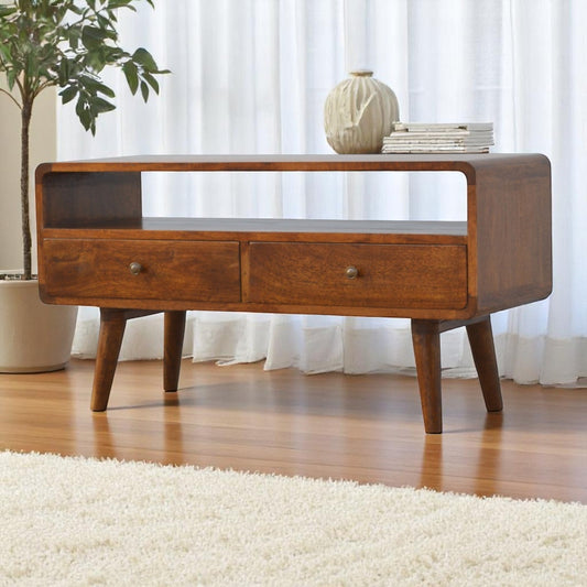 Wooden console table with two drawers in a room with white curtains and a plant.