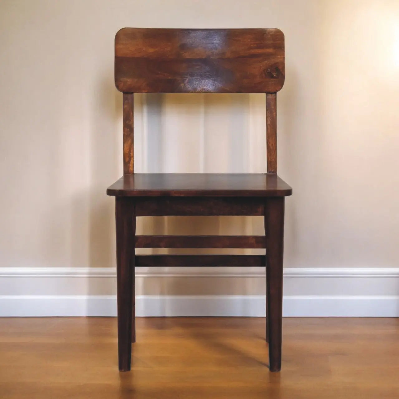 Wooden chair against a plain wall